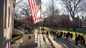 FILE - People take photos near a John Harvard statue, left, on the Harvard University campus, Jan. 2, 2024, in Cambridge, Mass.
