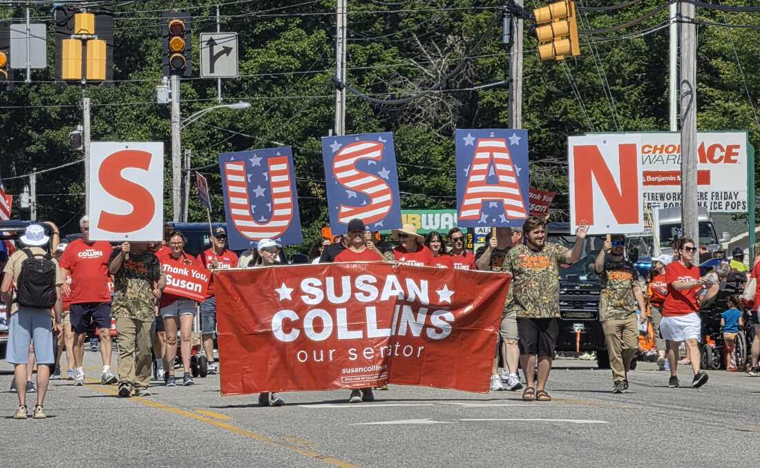 Lizbon, Maine'deki yıllık Moxie Günü Geçit Töreninde, R-Maine'den Senatör Susan Collins'in destekçileri, üzerinde SUSAN yazan tabelalar ve dev harflerle yürüyorlar.
