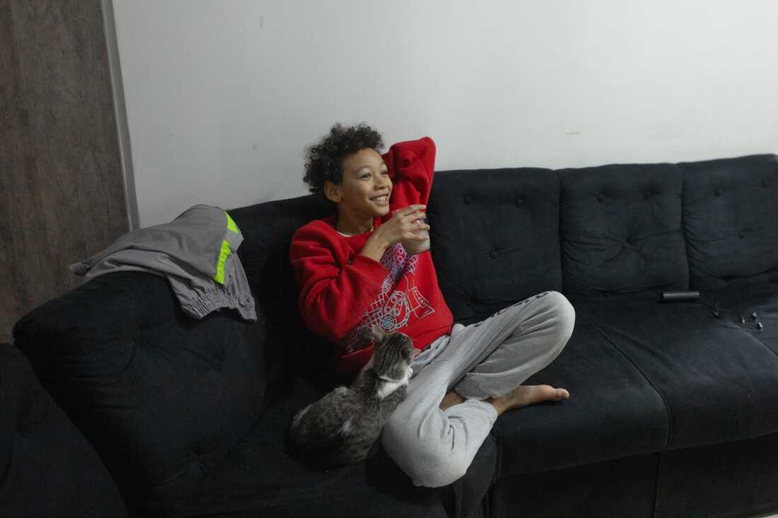 Henrique, son of Érica Lacerda de Souza and Bruce Lee de Souza, has breakfast on the couch in his family's new home in Guaianazes, São Paulo. 