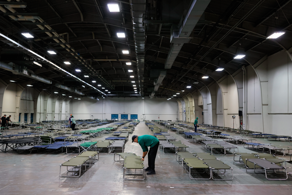 Volunteers prepare cots at an inclement weather shelter ahead of a winter storm at Fair Parks Automobile Building in Dallas, Texas on Friday, Jan. 23, 2026.