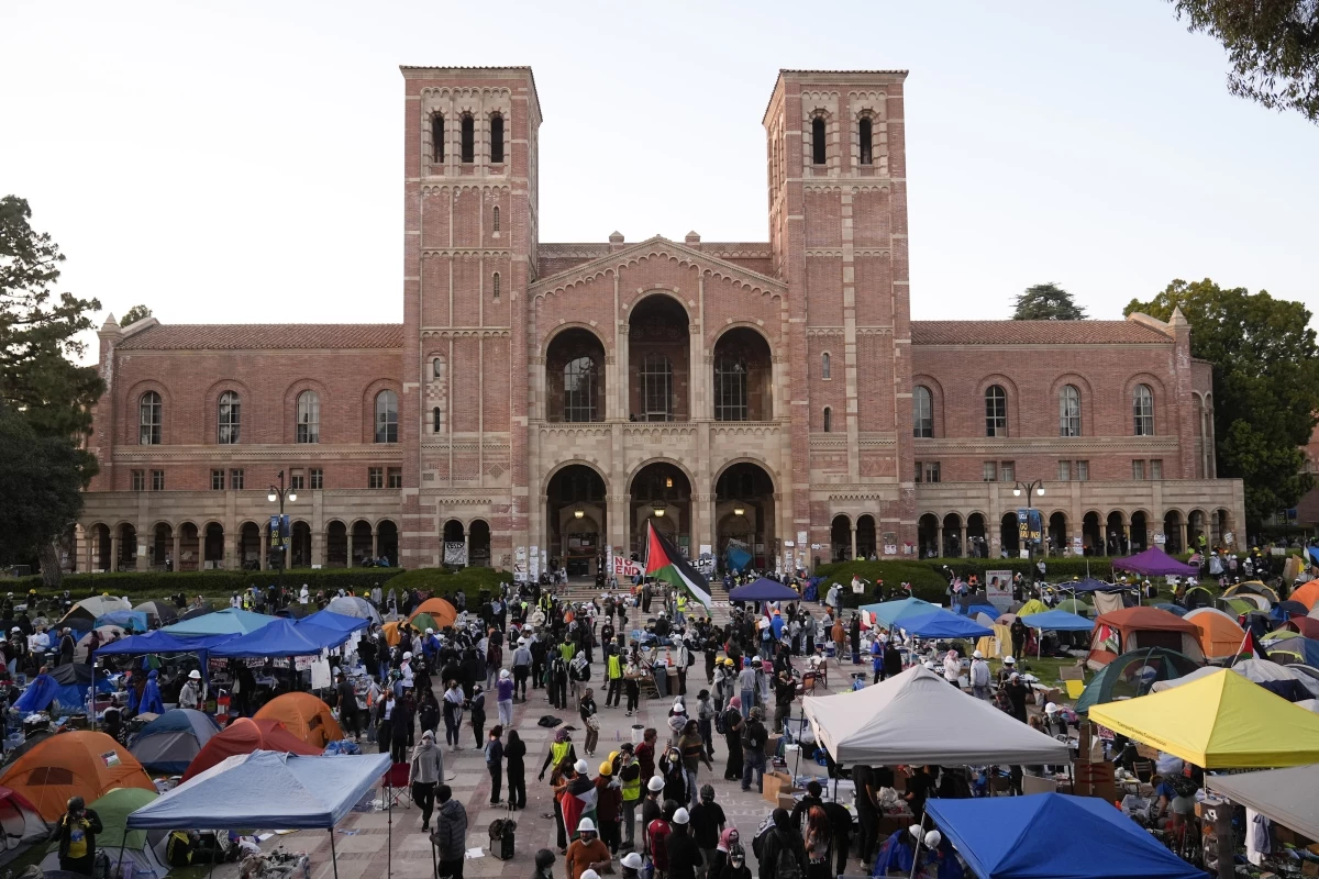 FILE - Demonstrators walk in an encampment on the UCLA campus after clashes between pro-Israel and pro-Palestinian groups, May 1, 2024, in Los Angeles.
