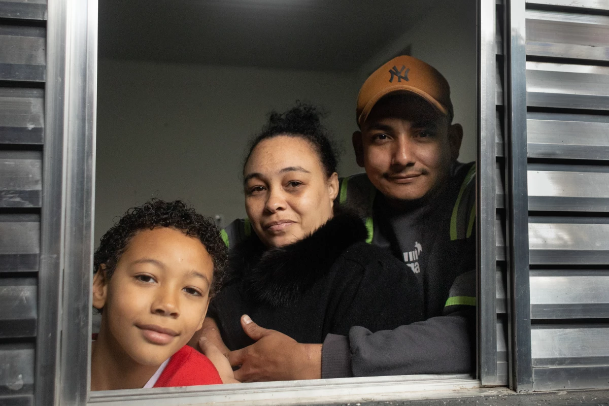 Erica Lacerda de Souza, son Henrique and husband Bruce Lee de Souza, relax in their new home in Guaianazes, São Paulo. The family lost their home when the pandemic took away their livelihoods. They moved in about two months ago after being homeless, then getting a tiny transitional residence/