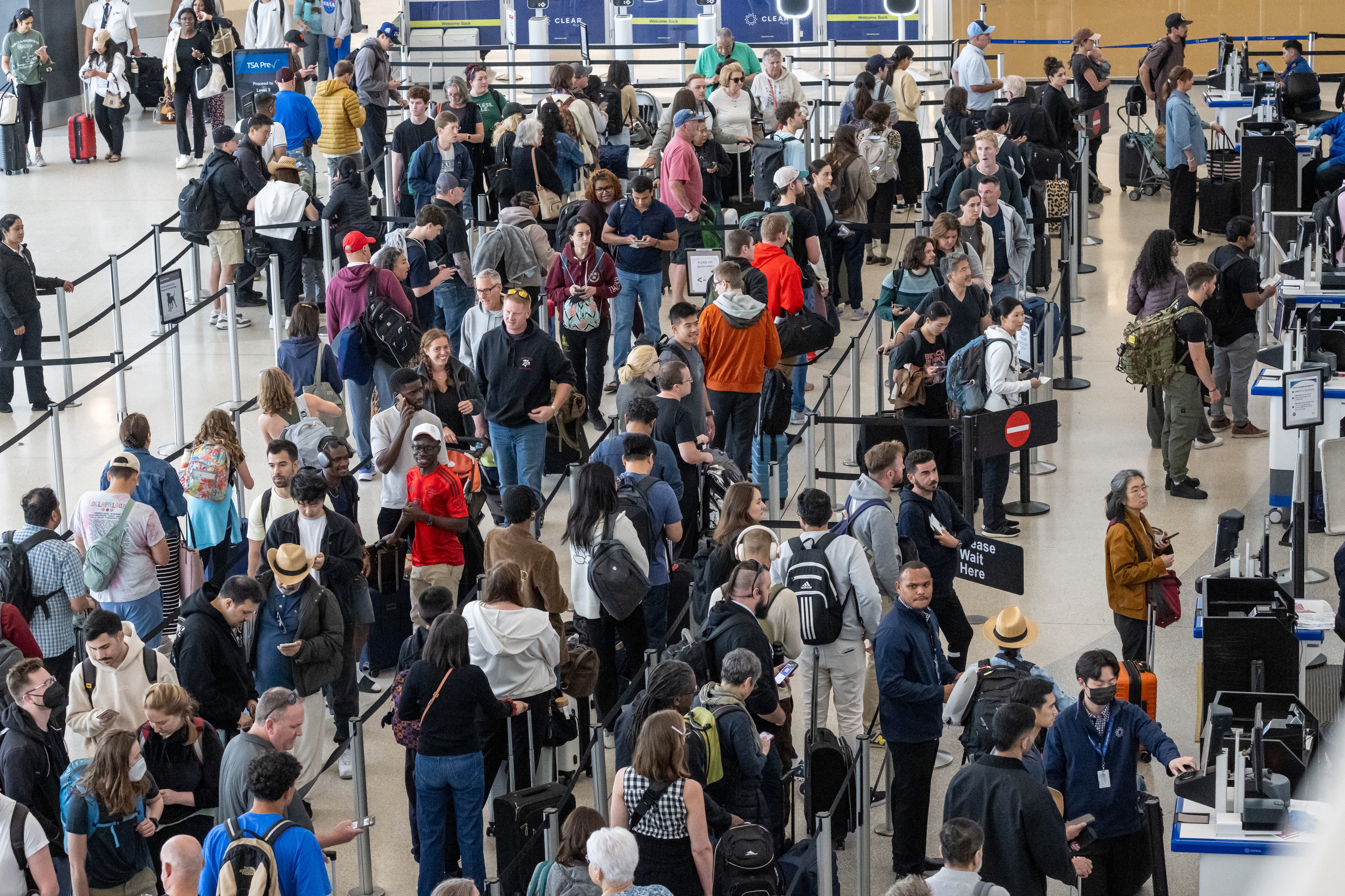 Travelers go through security at San Francisco International Airport the Friday before Memorial Day. AAA predicts Fourth of July weekend will be even busier.
