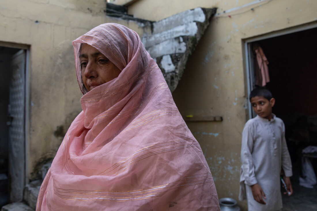 Saida Tanvir stands inside her partially damaged home near Bari Imam on August 20, 2026 in Islamabad, Pakistan. Her son Azeem Ahmed, 16, died while trying to block a bulldozer from crushing their roadside grocery store over the winter.