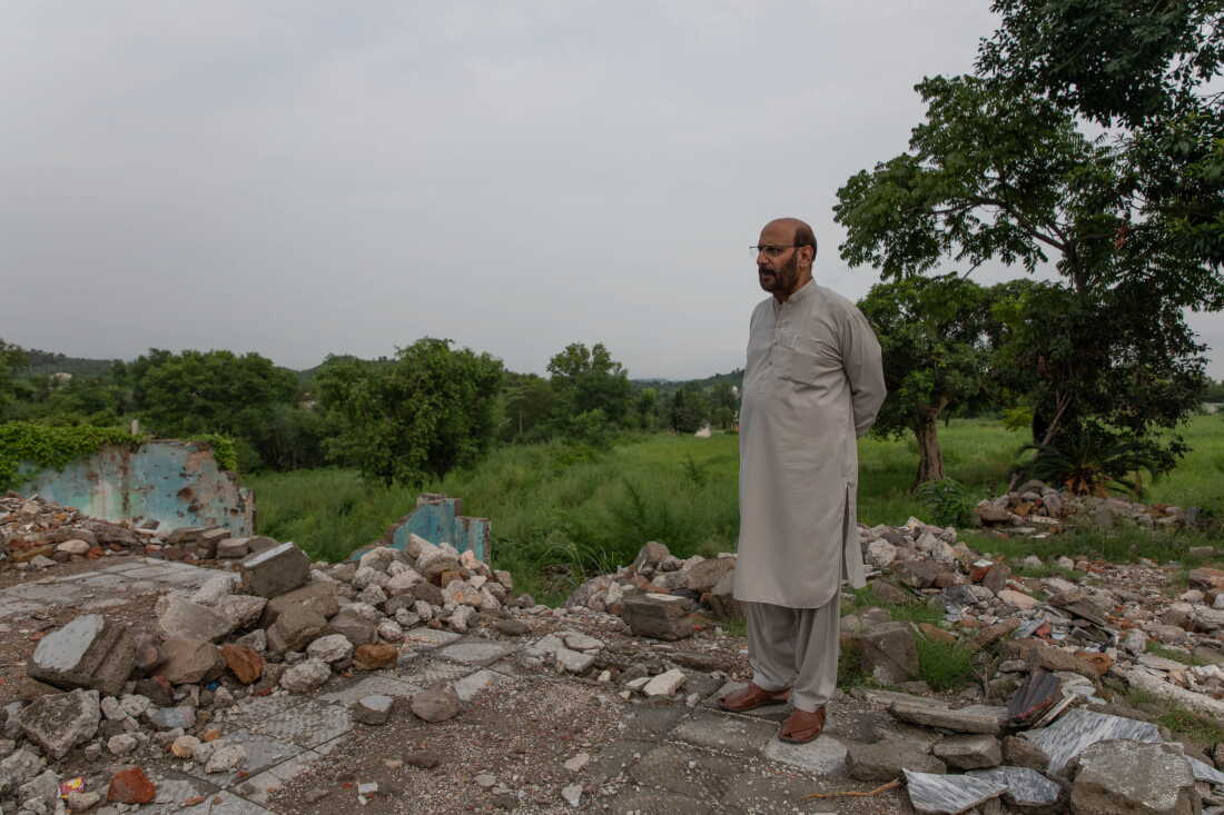 Tanvir Hussain, a lawyer and resident of Nurpur Shahan, stands near the demolished home of his friend on August 19, 2026 in Islamabad, Pakistan. He says decades-old compensation for land that was seized by the government in his area was never properly carried out.
