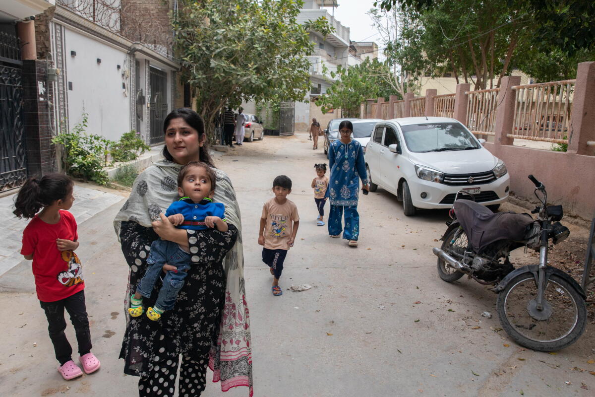 Umaima Ansari, whose 3-year-old son Hussain tested positive for HIV after an operation to address complications related to hydrocephalus, walks near her home with her children in Hyderabad, Pakistan. Ansari says multiple healthcare providers refused to treat her son, who also has cerebral palsy,  after learning about his HIV diagnosis.