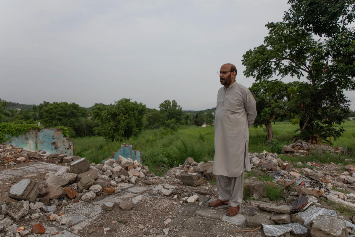 Tanvir Hussain, a lawyer, stands near the demolished home of his friend in Islamabad. He says that promised compensation for land seized by the government in his neighborhood decades ago was never properly carried out.