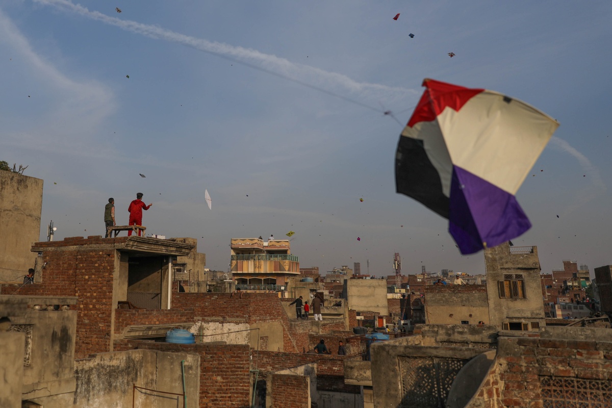 People gather on rooftops in Lahore's Old City to fly kites during Basant.