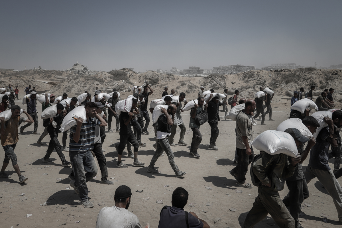 Palestinians carry aid supplies which entered Gaza through Israel in Beit Lahia, northern Gaza, on Sunday, July 27, 2025. But NGO's have said not enough food is being allowed into Gaza. Israel says the U.N. is holding up deliveries