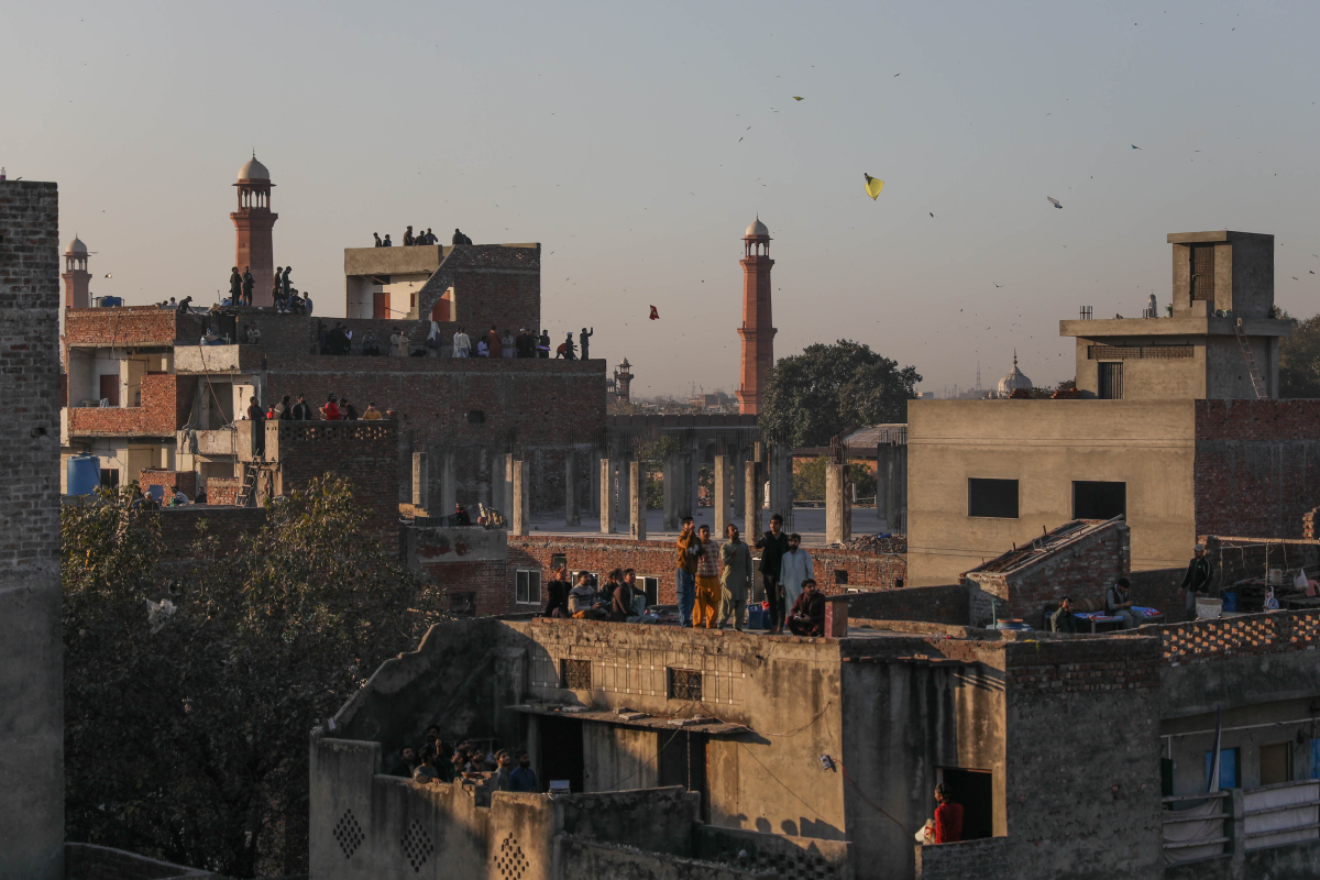 Kites dot the sky as people stand on rooftops in Lahore's Old City.