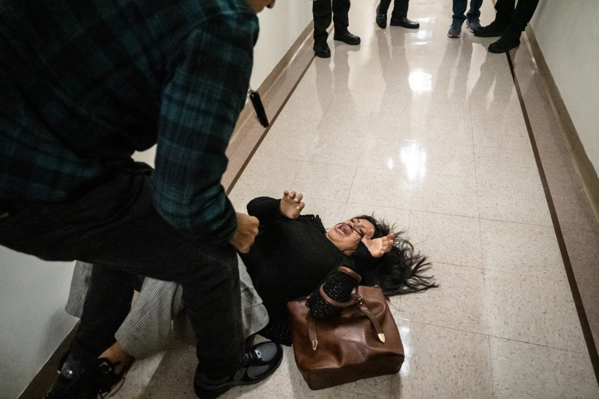 A federal agent pushes the wife of the detained man from Ecuador to the ground on September 25, 2025 in New York City.