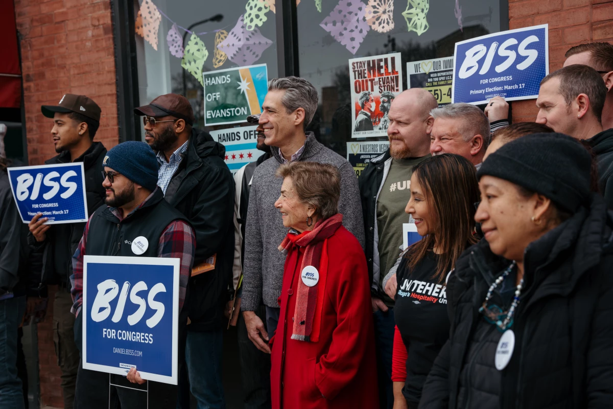 Volunteers gather with Schakowsky and Biss for a group photo outside Biss' campaign office before heading out to canvass ahead of the March 17, 2026 primary election. Biss is seeking the Democratic nomination in a crowded field of candidates.