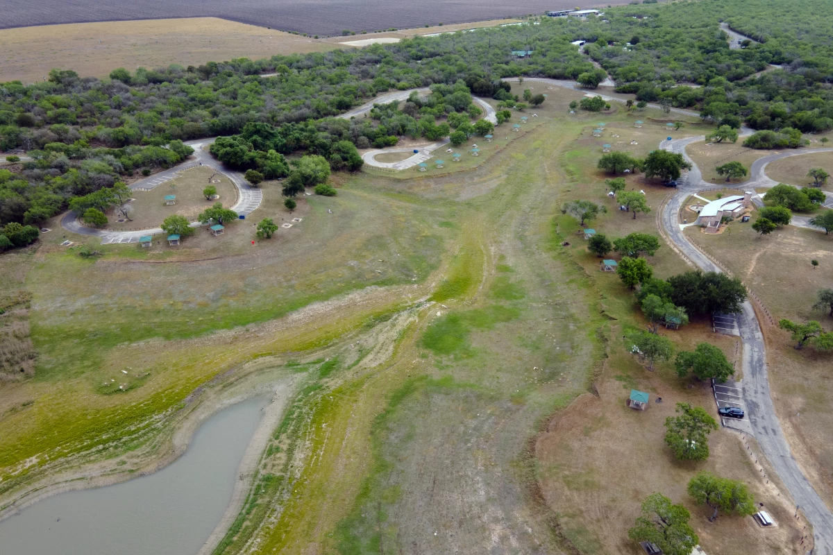A top-down aerial view of Lake Corpus Christi reveals dry lakebed and shrinking water levels as drought continues to strain the region's supply on April 10, 2026. 