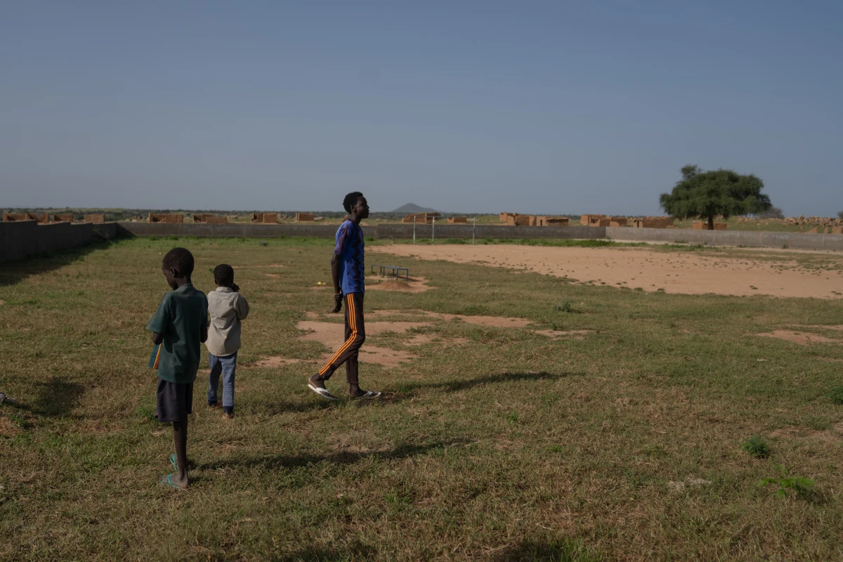 Mahamat DJouma, 14, with two of his younger brothers at the soccer field where he likes to play. He has nicknames for the boys: 'Doctor' for Hassan, because his mother had said he took his time emerging from her womb during birth, and 'Azak' for Hissein, which means intelligent in Arabic. 'Because he's smart,' Mahamat adds proudly.