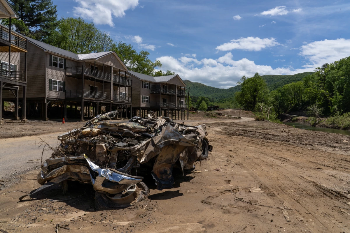 The remnants of a Dodge Ram pickup lay in front of a series of housing complexes, all damaged by the flooding following Hurricane Helene. Two of the buildings that would have blocked the view of the mountains beyond the pickup were completely washed away during the flooding.