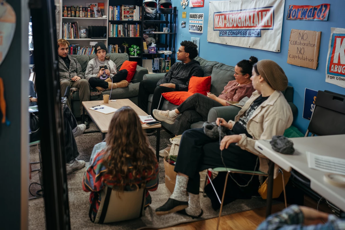 A group of supporters sit with Abughazaleh as they knit and discuss political issues inside her campaign office.