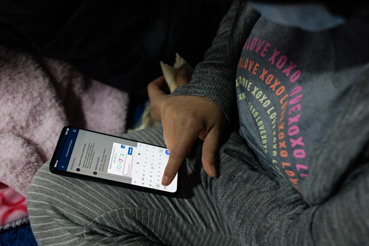 Venezuelan Bárbara Mendoza, 28, logs into the CBP One application atop her bunk in El Buen Samaritano migrant shelter in Ciudad Juárez, Chihuahua state, Mexico on Monday, December 9, 2024.