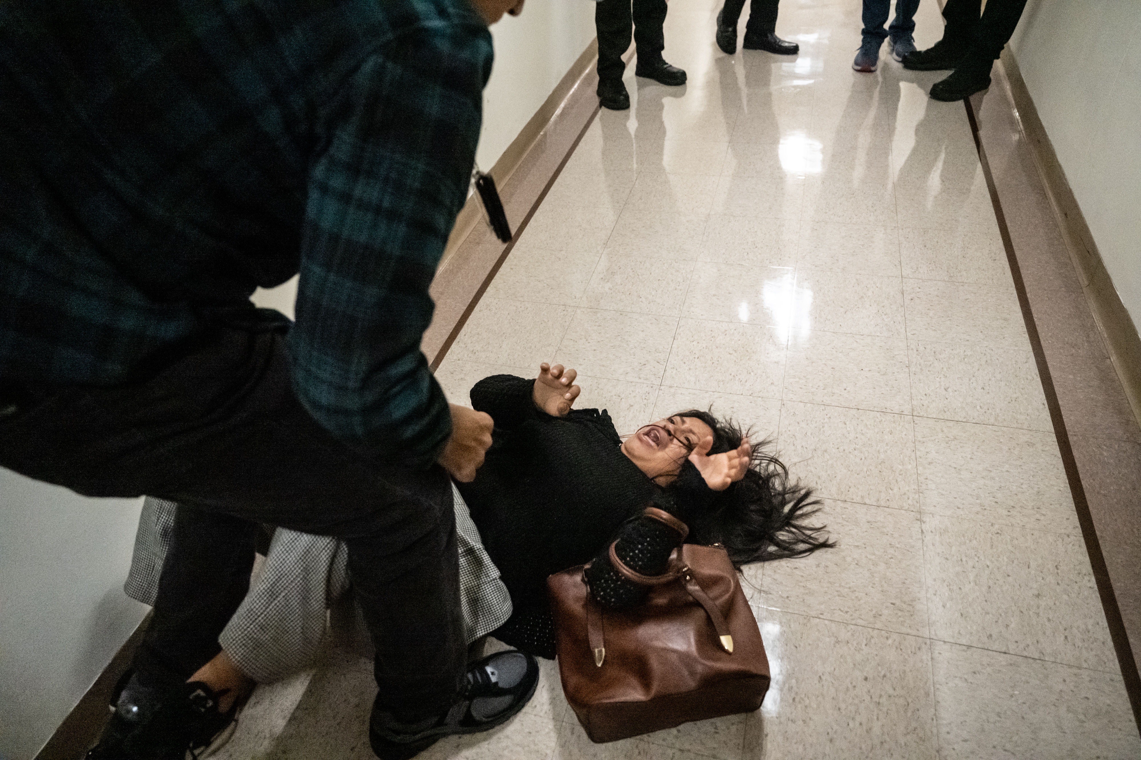 A federal agent pushes the wife of the detained man from Ecuador to the ground on September 25, 2025 in New York City.