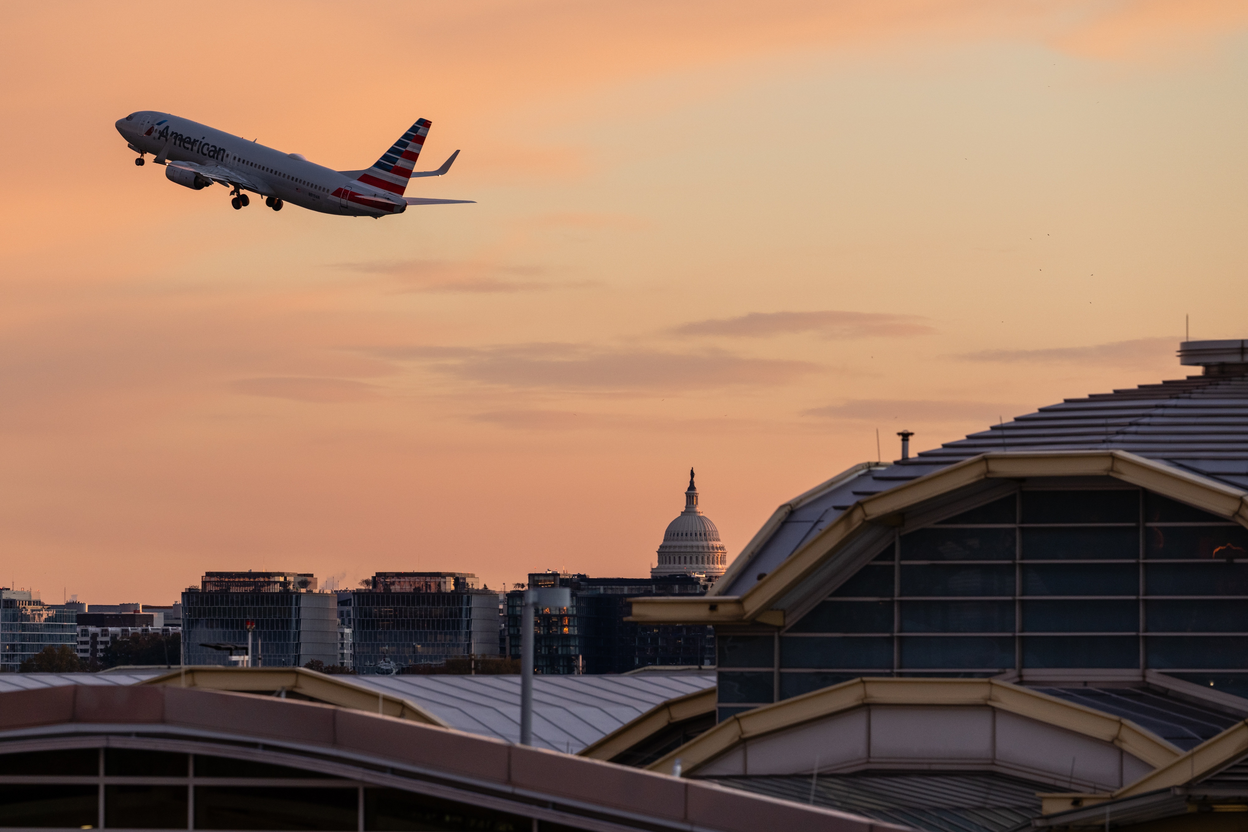 A flight takes off from Reagan Washington National Airport in Arlington, Va., on Tuesday, with the U.S. Capitol in view. The federal government reopened Wednesday, but some of the impacts will be felt longer.