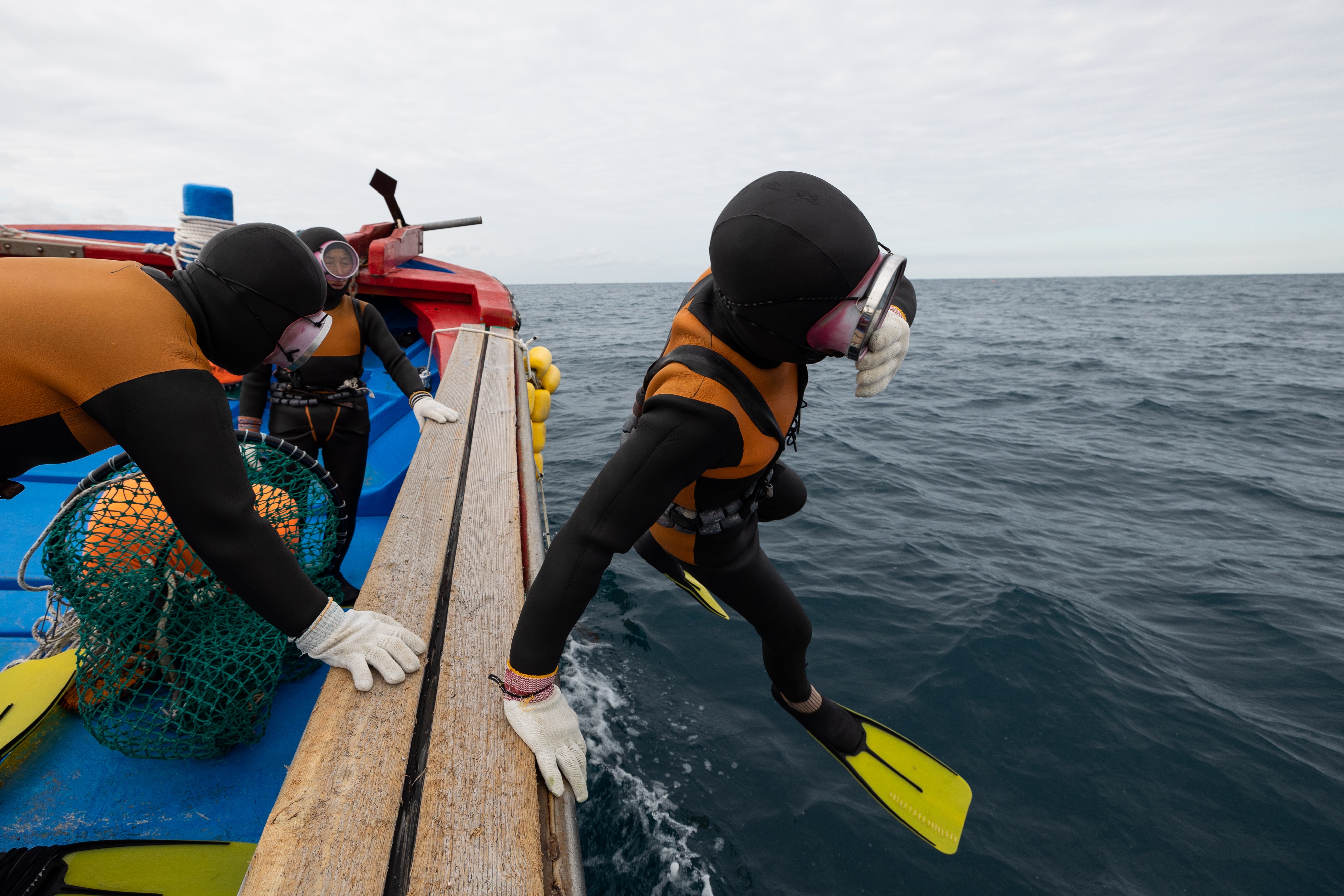 A South Korean female free diver jumps into the sea from a boat off the coast of Jeju Island on Saturday, Jan. 15, 2022. New research has found that these women, known as Haenyeo, have specific genetic adaptations connected to cold tolerance and blood pressure.