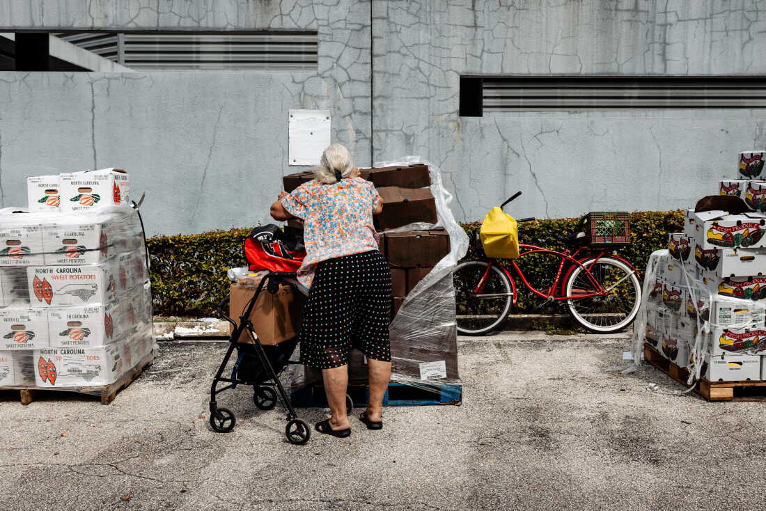 A resident receives donated food items at Curley's House Food Bank last year in Miami, Fla.