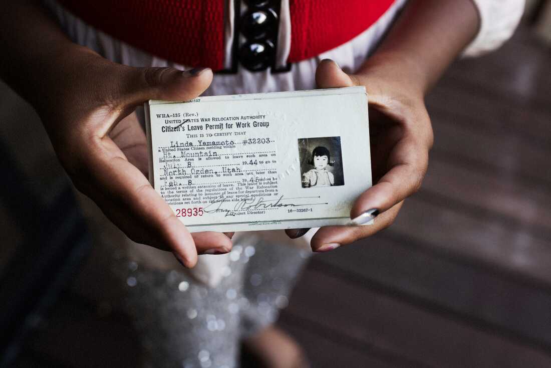 Desai holds the ID issued to Linda Yamamoto (now Linda Horikawa) by the US War Relocation Authority.