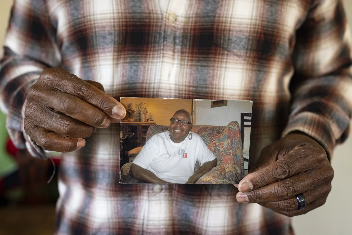 Leslie Adams holds a photo of his mother, Shirley, who died after developing infected bedsores at a rehabilitation center, according to a lawsuit he filed. A court awarded the family $17 million, but they are still trying to collect it.