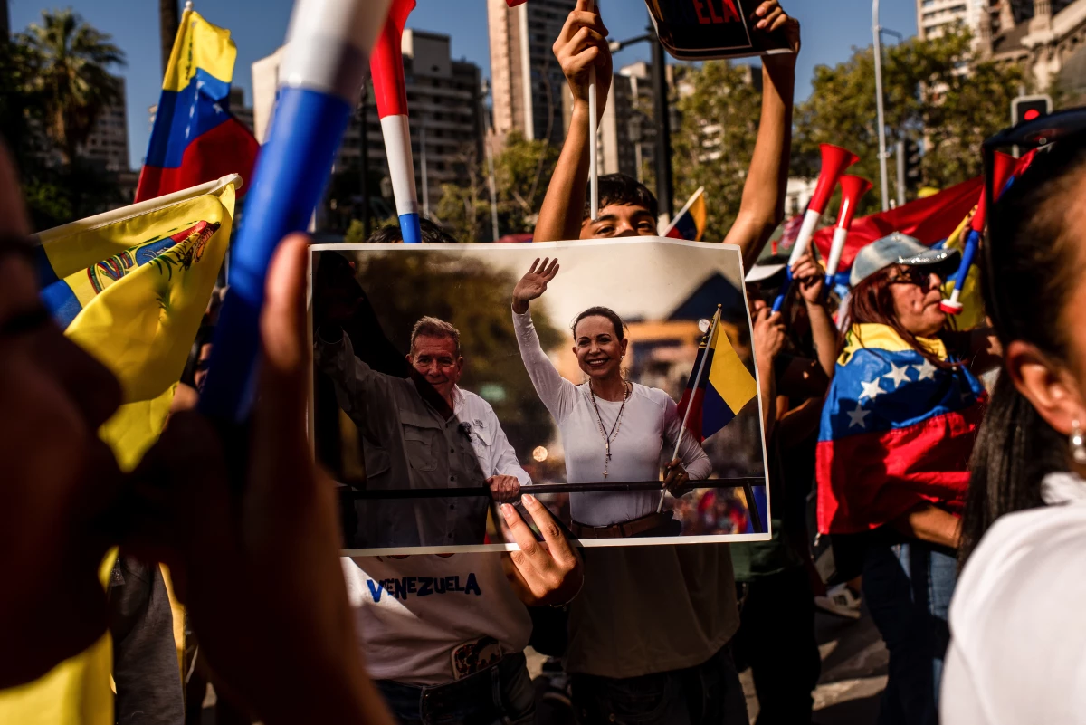 A resident holds an image of Venezuelan opposition leader María Corina Machado during a celebration in Santiago, Chile, on Saturday, after U.S. forces seized Venezuela's leader Nicolás Maduro.