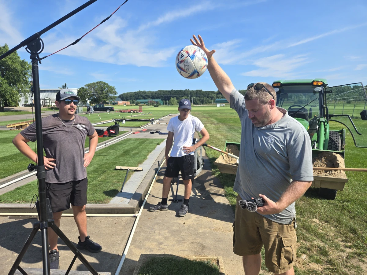 Michigan State University lead research associate Ryan Bearss and students drop soccer balls on several experimental patches of turf to determine whether their bounce meets regulation height.
