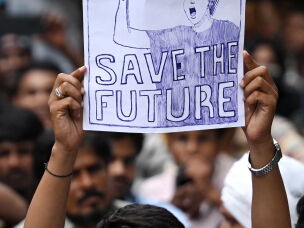 A demonstrator holds a placard at Jantar Mantar in New Delhi on July 24, 2026 during the ongoing Cockroach Janta Party (CJP) protest to demand the resignation of India's Education Minister Dharmendra Pradhan over alleged NEET exam irregularities.