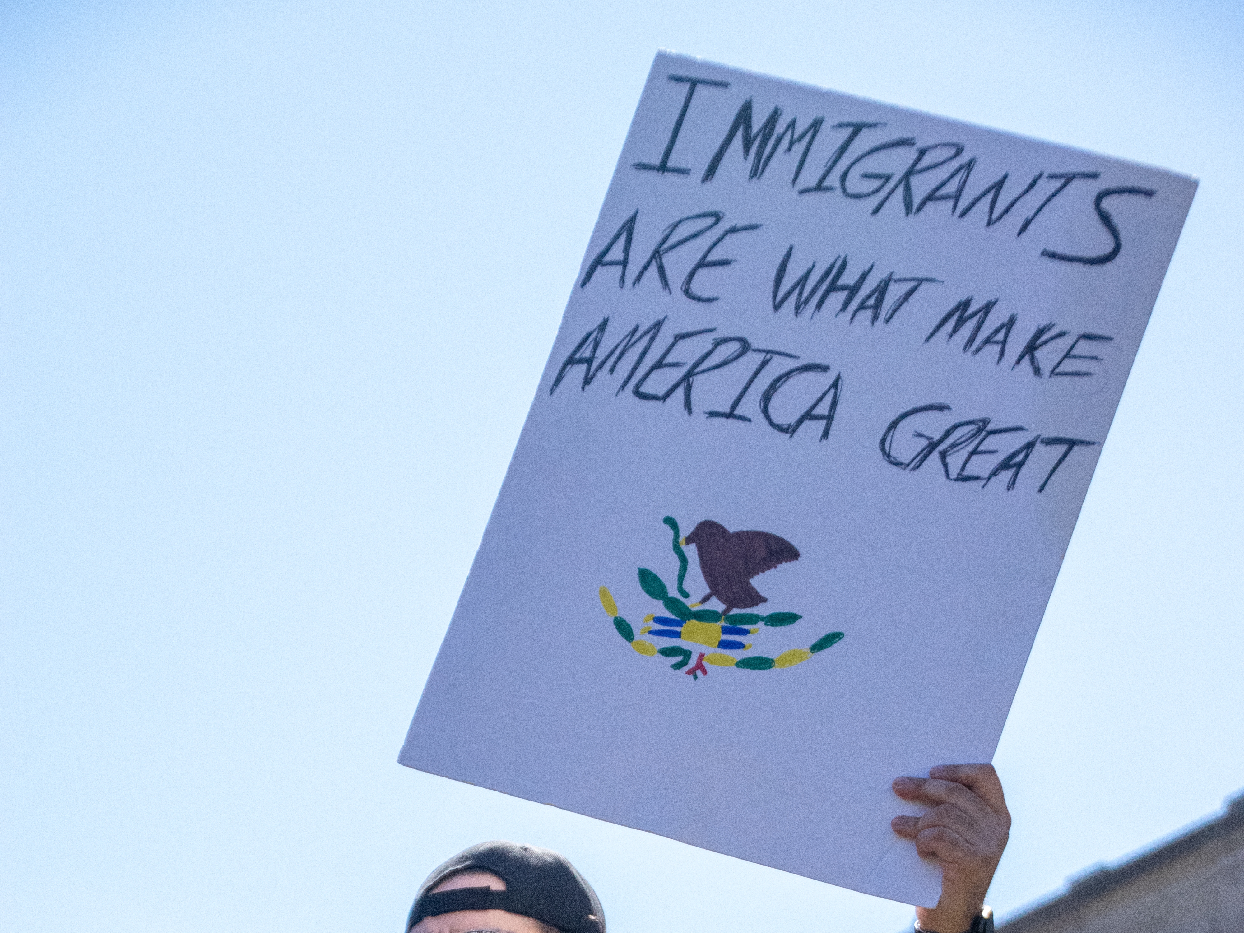 Ella AbbottOne protester stands on top of one of the fountains on the Allen County Courthouse green on Saturday with a sign that reads immigrants are what makes America great. Many protests have seen an uptick in anti-ICE sentiment since the mass mobilization of the organization earlier this year.