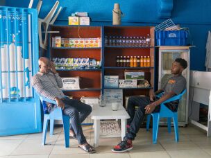 Gilly Claude Uwizeyamana (left) and Gilles Bertrand Niyomwungeri take a milk break. The Rwandan custom is to sit down when drinking milk, out of respect for cows, which are seen as symbols of prosperity.