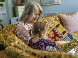 Mary Jo Galusha reads to her granddaughter, Robin, 23 months, at her home in Newark.