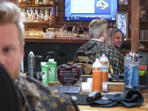 Eric Sauter, a frequent flyer, gets his hair cut at The Director's Cut: Take Two, a barbershop at Kansas City International Airport, on June 2.