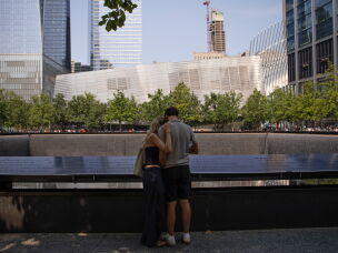 A couple embraces at one of the 9/11 Memorial's twin reflecting pools. The memorial's two reflecting pools sit where the twin towers once stood.