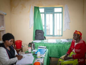Nurse Diane Kwizera meets with Consolée Uwamaliya at a health facility near the Cyangoga Suspension Bridge, which spans a river that separates two communities. The bridge makes it easier for residents of the settlement on the other side of the river to come in for healthcare.
