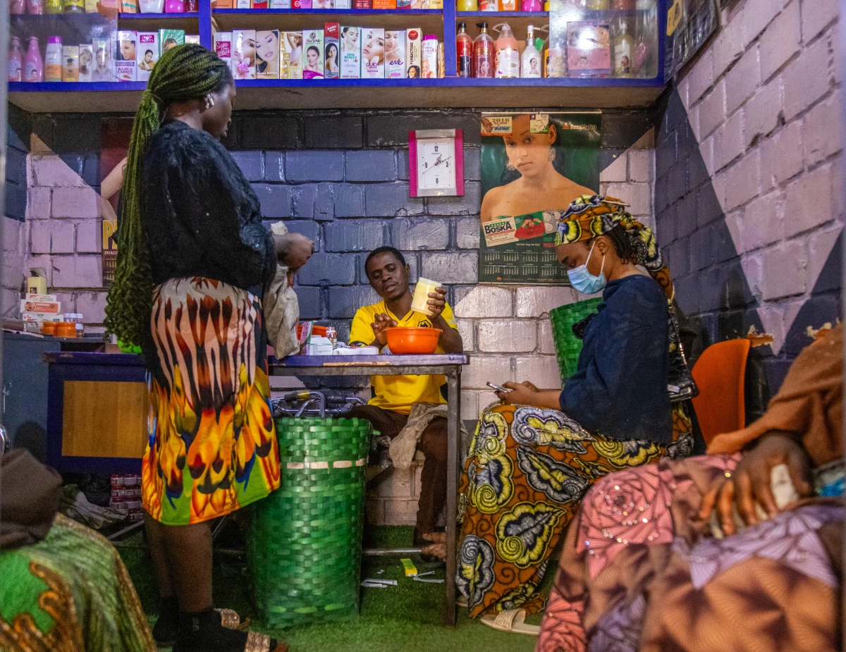 An assistant at a shop in Kano, Nigeria, mixes a concoction of creams and gels and cracks a few capsules to add in, creating a skin bleaching product for the waiting customers.