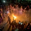 A frame grab from footage circulating on social media shows protesters dancing and cheering around a bonfire.