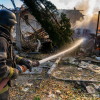 A rescue worker puts out a fire at residential houses destroyed in a Russian strike on Kharkiv, Ukraine, Sunday, Oct. 11, 2026.