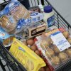 A grocery cart is full of food items.