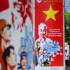 Vietnamese men stand along a street adorned with posters commemorating the 50th anniversary of the end of the Vietnam War in Ho Chi Minh City on April 29, 2025. (Photo by MANAN VATSYAYANA / AFP) (Photo by MANAN VATSYAYANA/AFP via Getty Images)