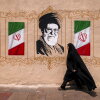 A woman walks past a mural depicting Iran's late supreme leader, Ayatollah Ali Khamenei, at Valiasr Square in central Tehran, on Aug. 8.