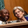 Sen. Tim Scott, seated on the left side of the frame, chats with Sen. Elizabeth Warren, seated on the right side of the frame, during a hearing on Capitol Hill in June 2025.