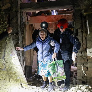 A policeman helps an elderly woman to walk out from a residential building damaged by a Russian airstrike in Zaporizhzhia, Ukraine, on Saturday.