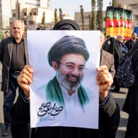 A supporter poses with a picture of Iran's new supreme leader, Mojtaba Khamenei, during a rally in central Tehran on Monday.