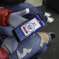 A person tries to use the CBP One app on their phone.