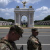 National Guard Members walk near a replica of President Trump's proposed arch at the Great American State Fair on the National Mall in Washington, DC, in July.