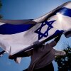 People dance and wave large Israeli flags during a rally against campus antisemitism at George Washington University in May 2024 in Washington, D.C.