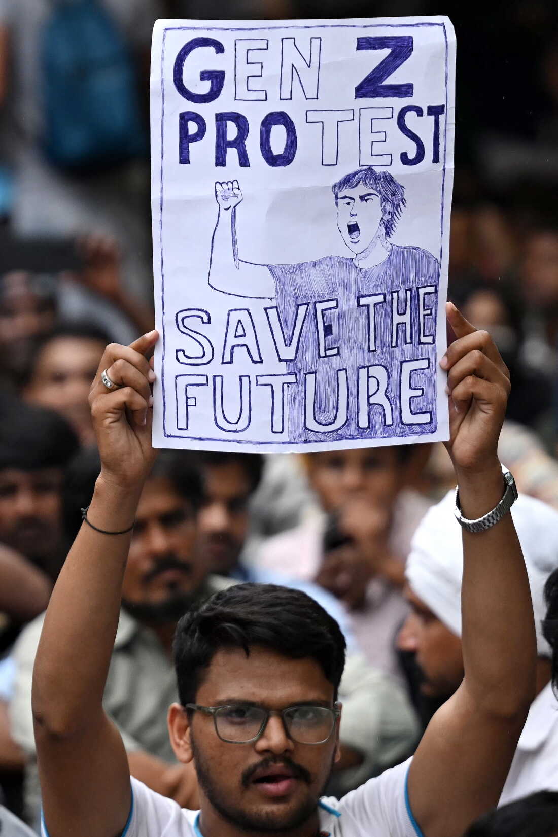 A demonstrator holds a placard at Jantar Mantar in New Delhi on July 24, 2026 during the ongoing Cockroach Janta Party (CJP) protest to demand the resignation of India's Education Minister Dharmendra Pradhan over alleged NEET exam irregularities.