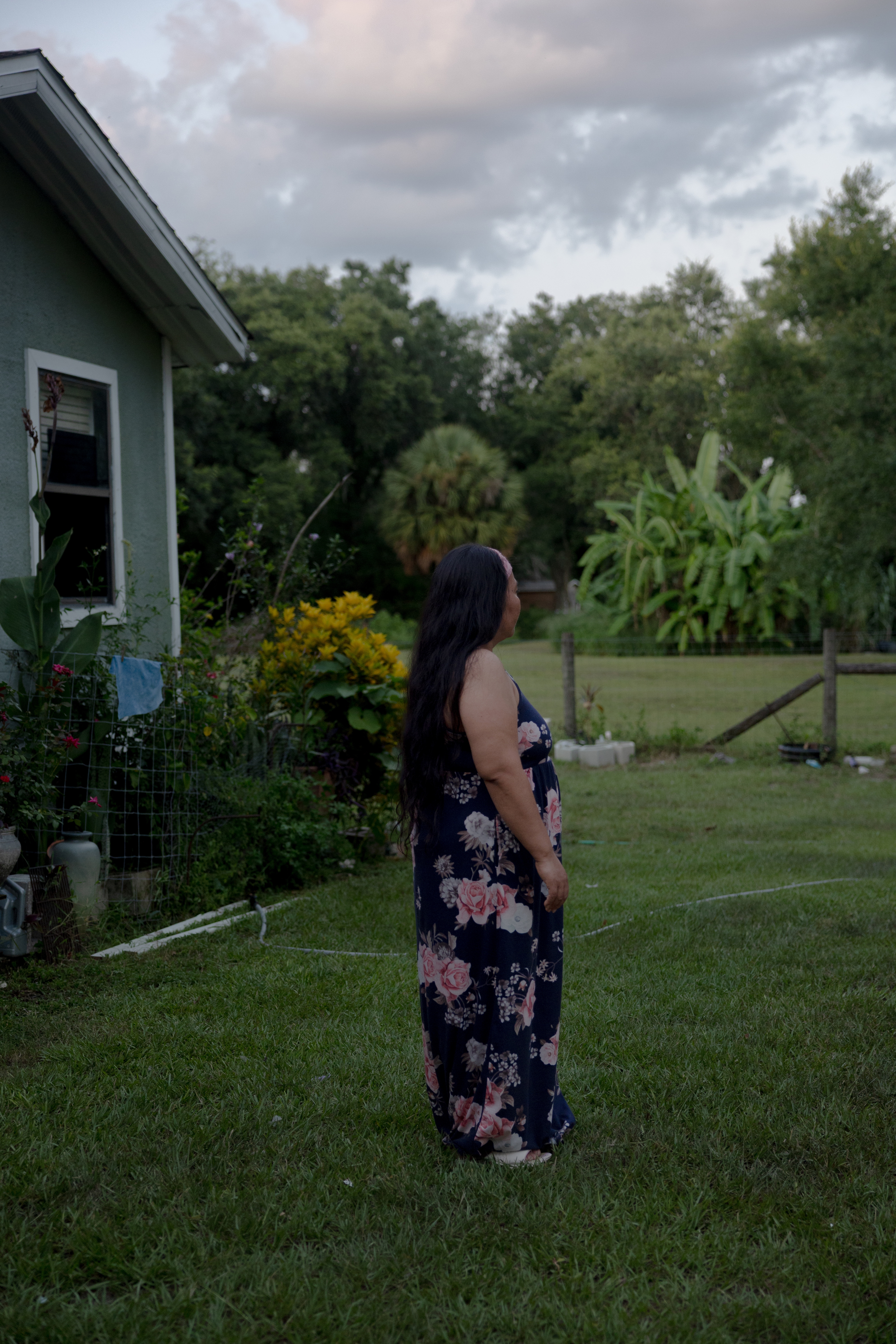 A woman poses for a portrait outside her home, Saturday, July 19, 2025, in Tampa. Her family are discussing emergency plans if she or her husband were to be detained, and are looking to move to another state where the police presence is less felt.
(Lexi Parra for NPR)
